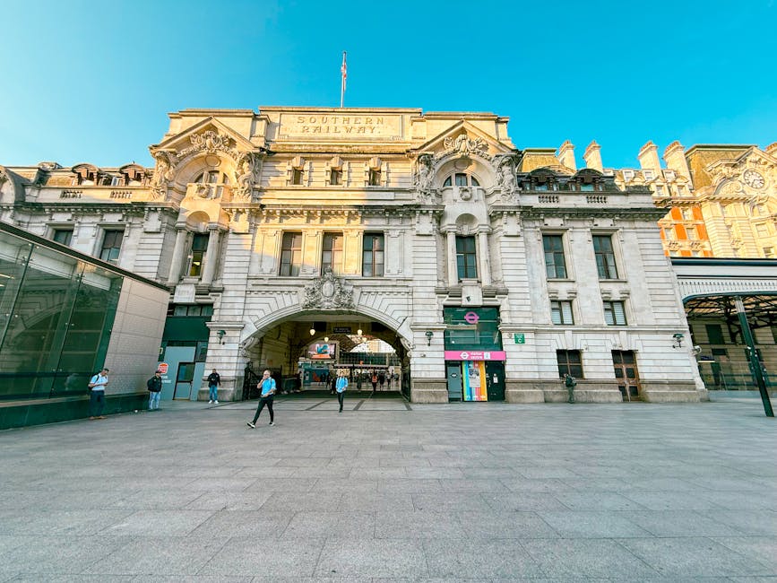 A wide view of the historic London Bridge Station building, featuring ornate stonework and classic architectural details, with the Southern Railway sign visible at the top. The foreground shows a spac